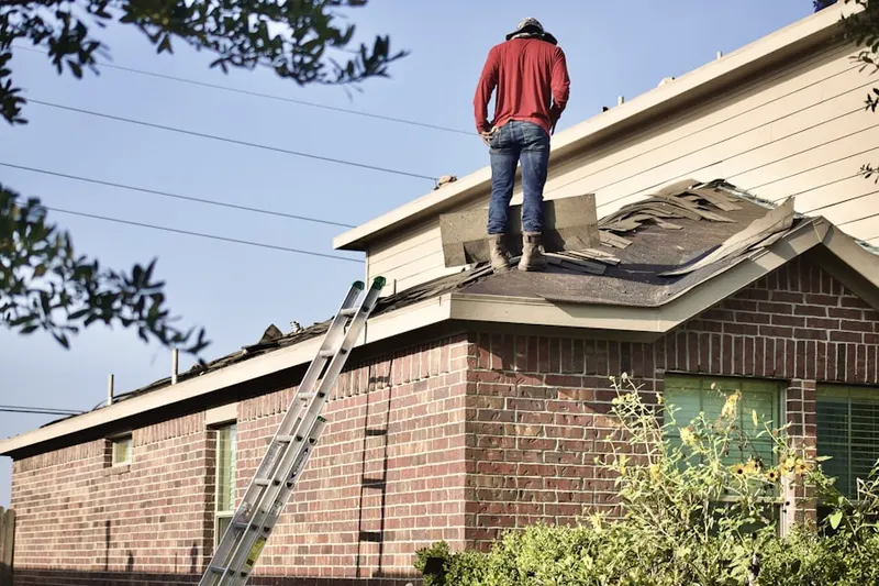 Professional roofer working on a residential roof in Penderbrook